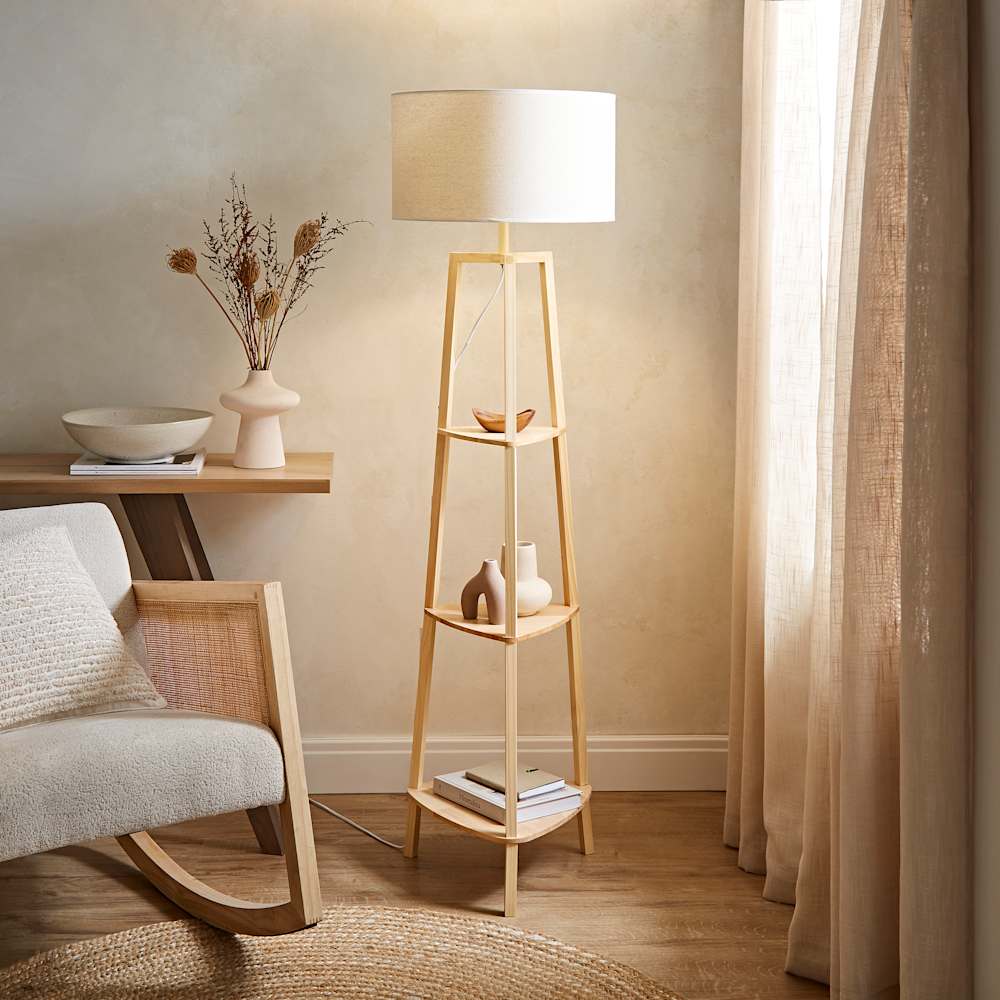 Scandi-style wooden floor lamp with shelves and fabric shade adding soft warm light to a calm neutral living room
