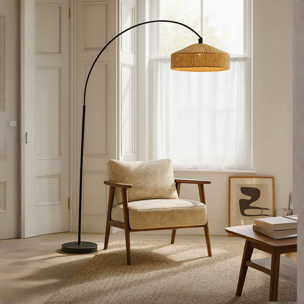 Louis Arch Black Floor Lamp with Brown Rattan Shade displayed in a light and airy neutrally decorated living room next to an armchair